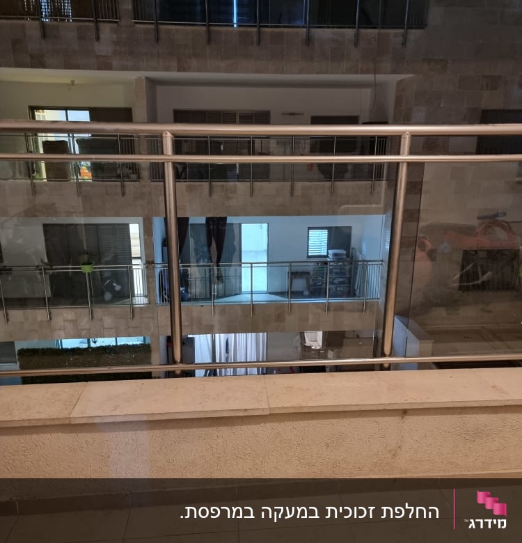 מעקה זכוכית עם מסגרת מתכת במרפסת בניין